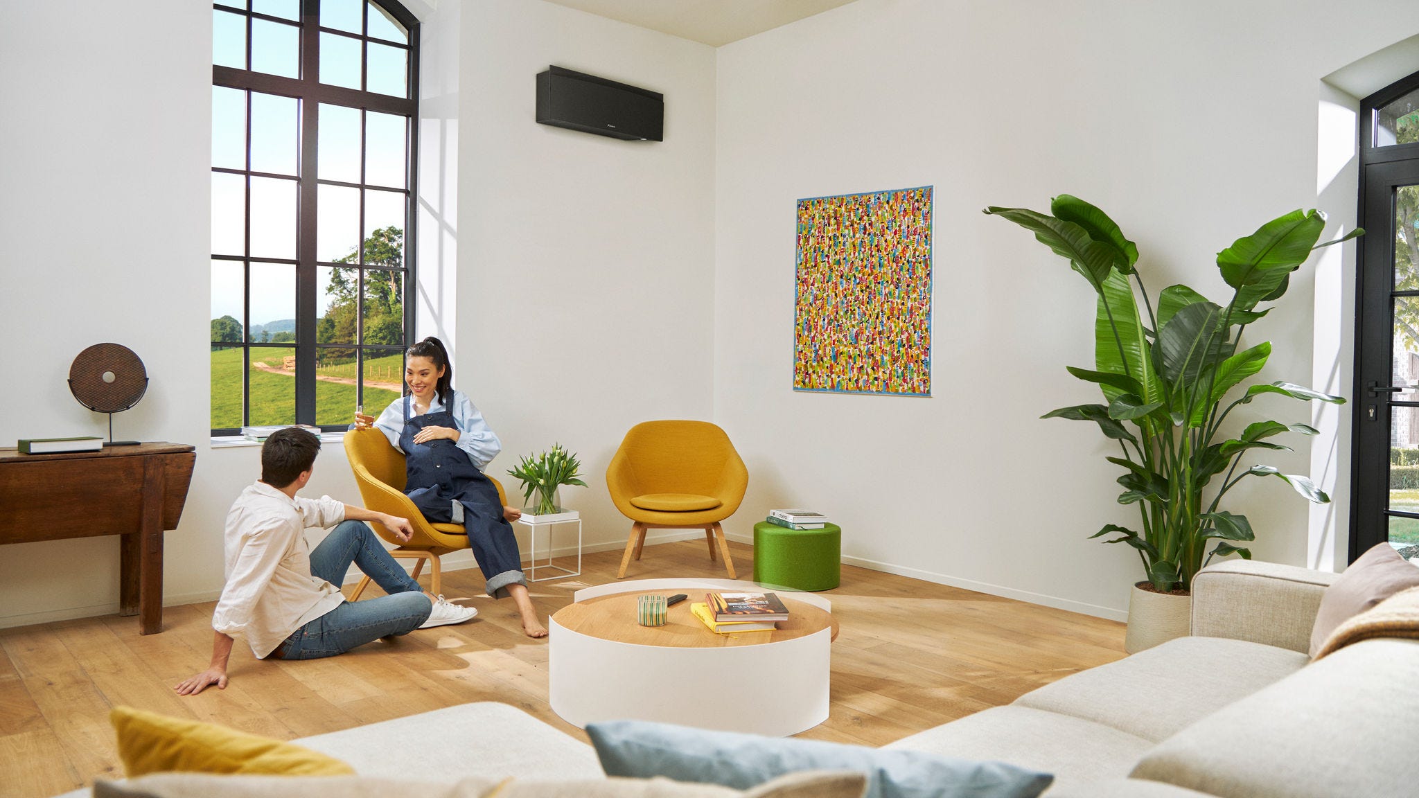 Para w ciąży swobodnie rozmawiająca, podczas gdy kobieta siedzi na krześle.