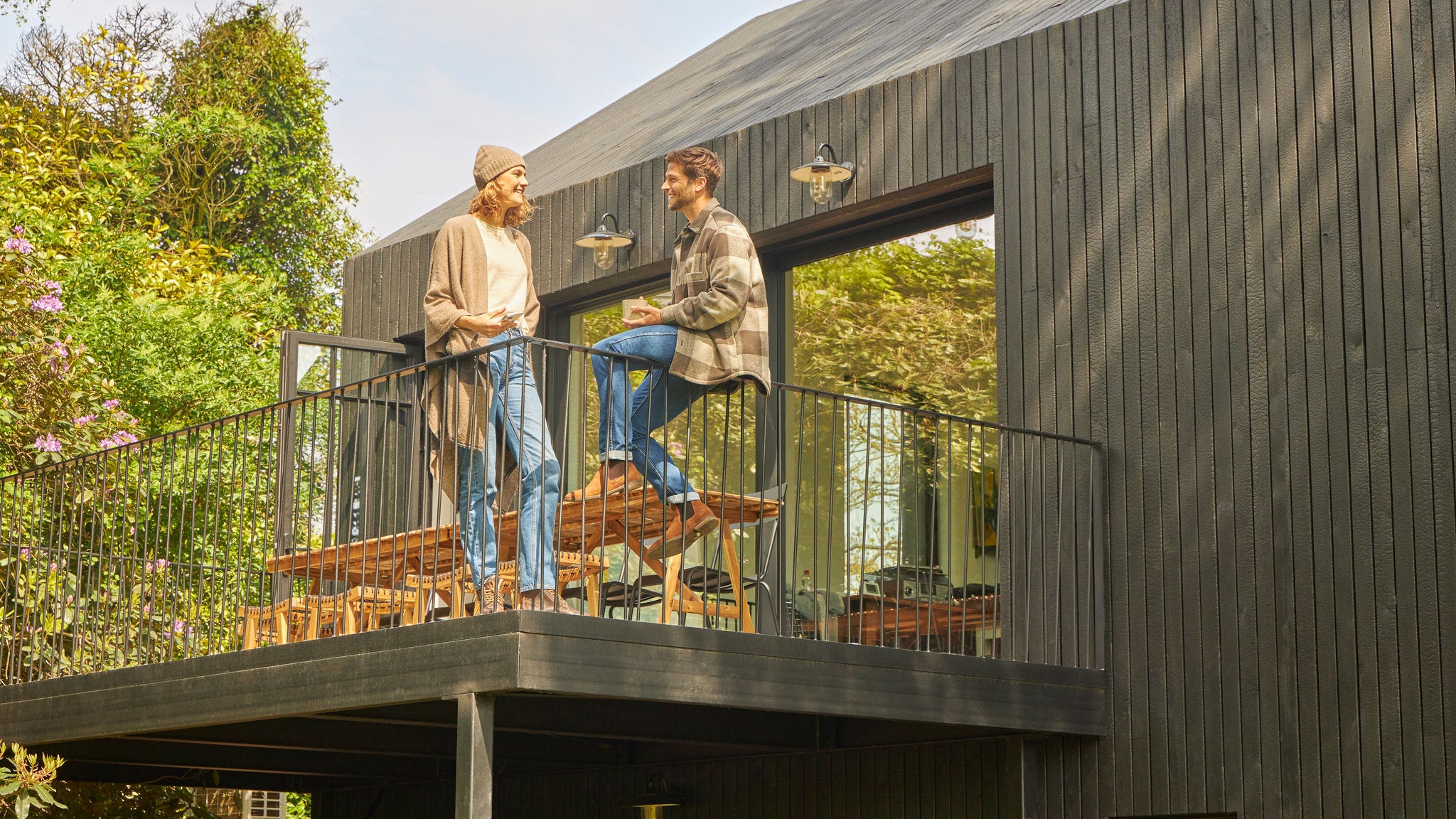 Para rozmawia na tarasie bungalowu na łonie natury