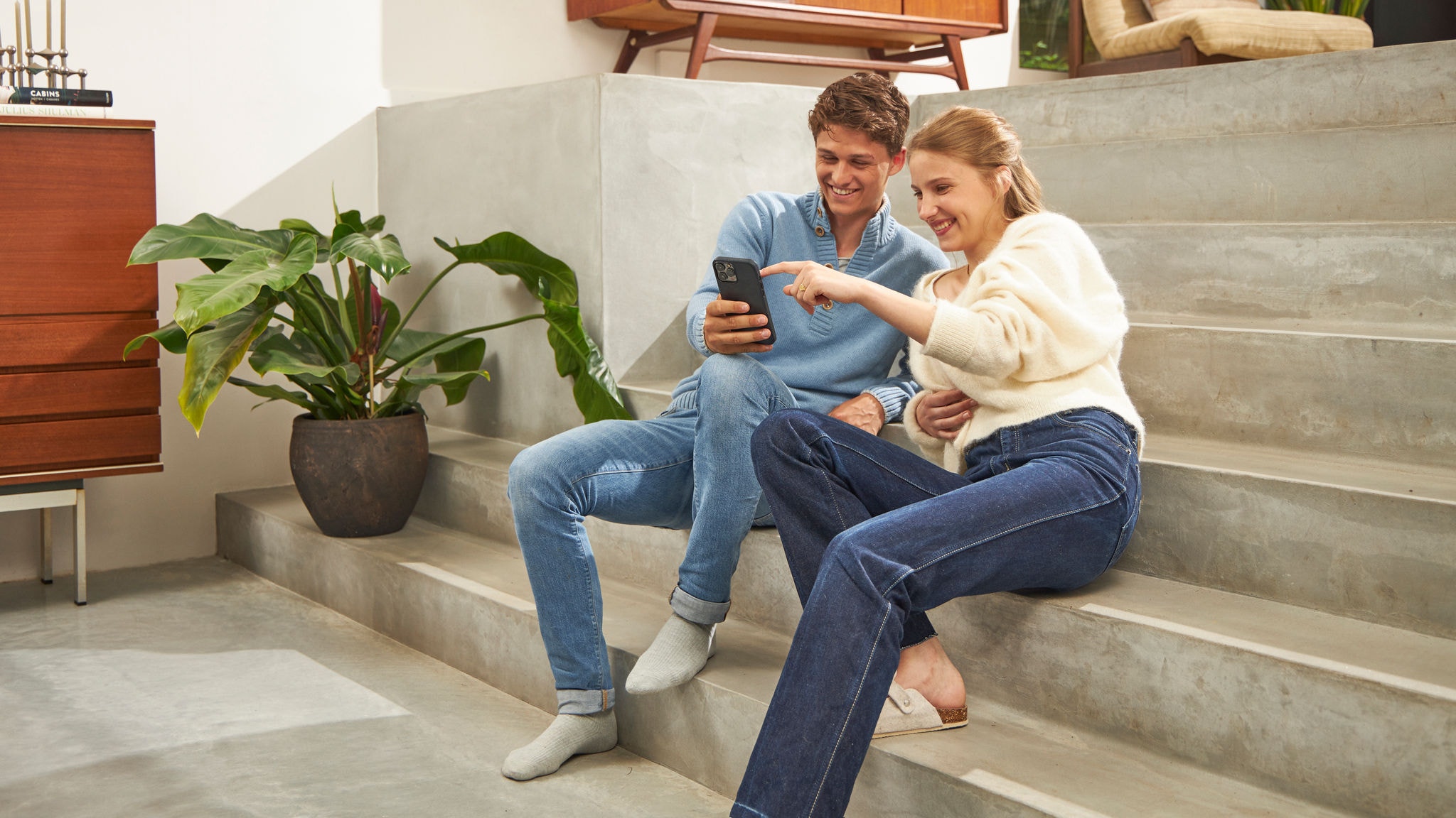 Mężczyzna i kobieta patrzący na telefon i uśmiechający się