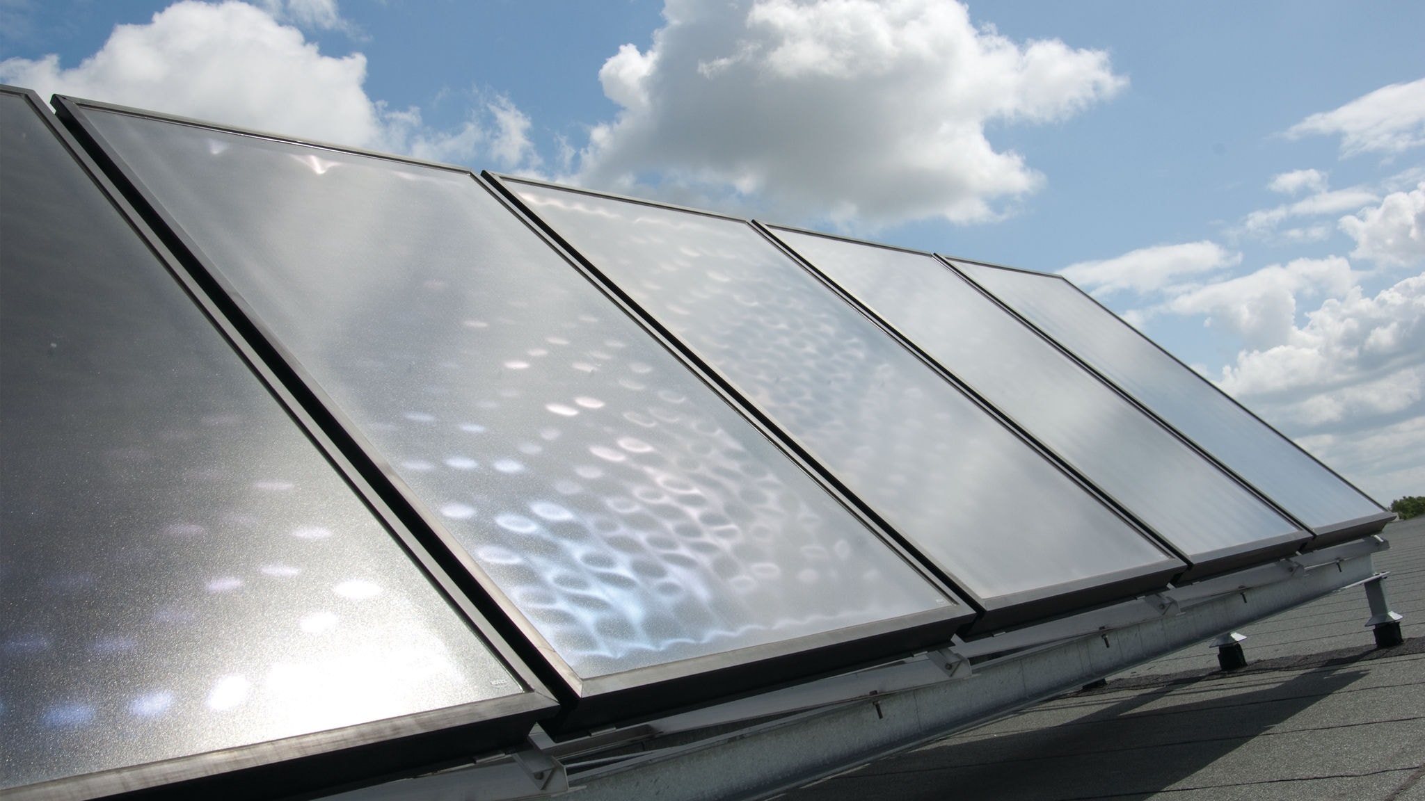 Panele słoneczne zainstalowane na dachu i połączone z pompą ciepła Daikin w celu uzyskania efektu synergii i zaoszczędzenia pieniędzy
