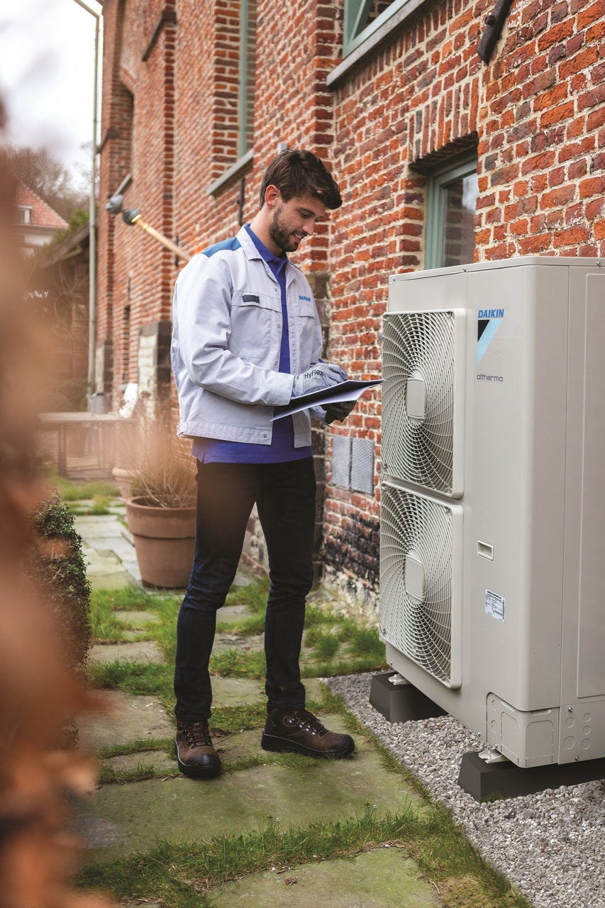 Mężczyzna instalujący jednostkę zewnętrzną.