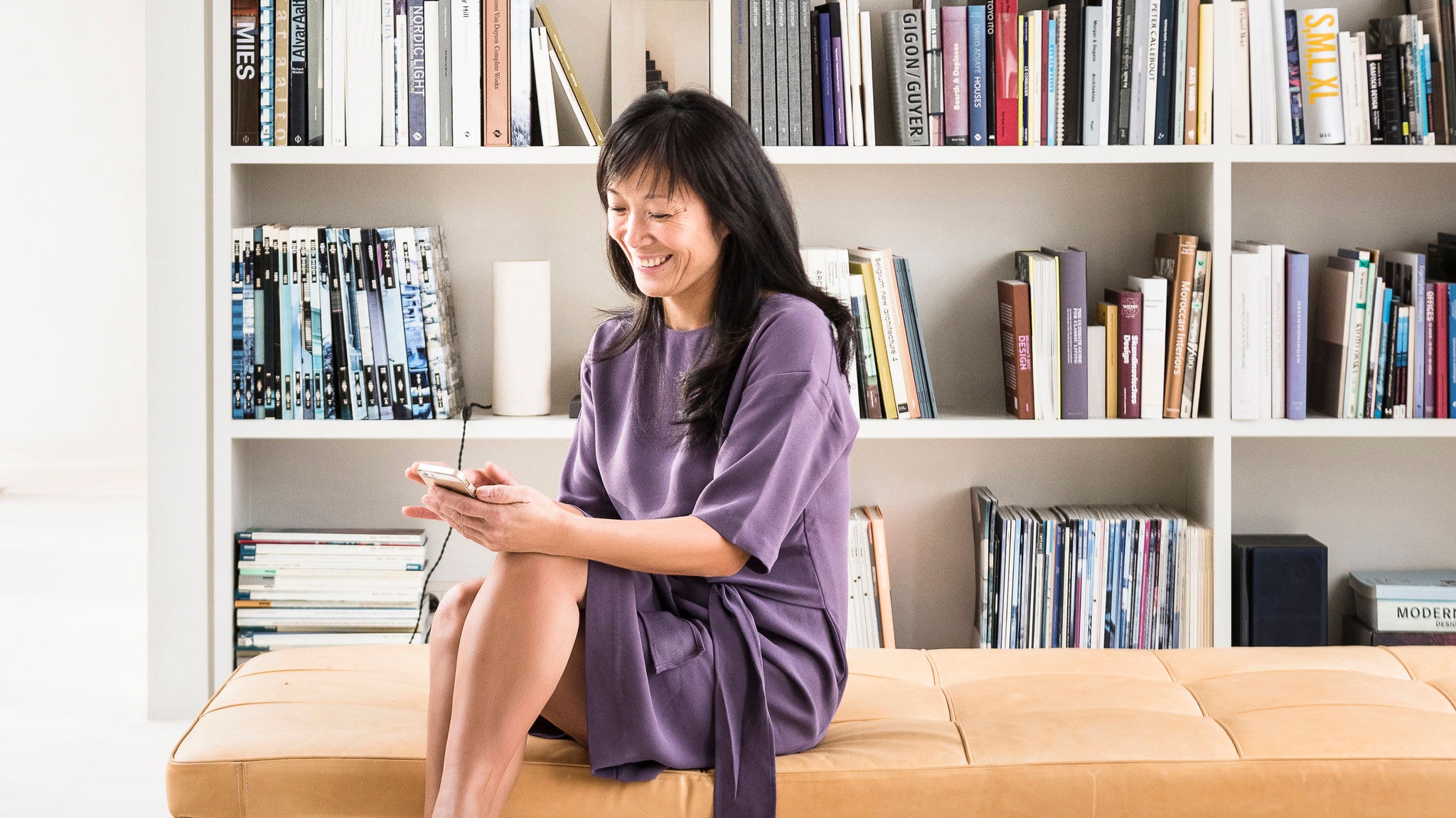 Kobieta korzystająca z aplikacji Onecta do sterowania ogrzewaniem, chłodzeniem i ciepłą wodą w swoim domu.