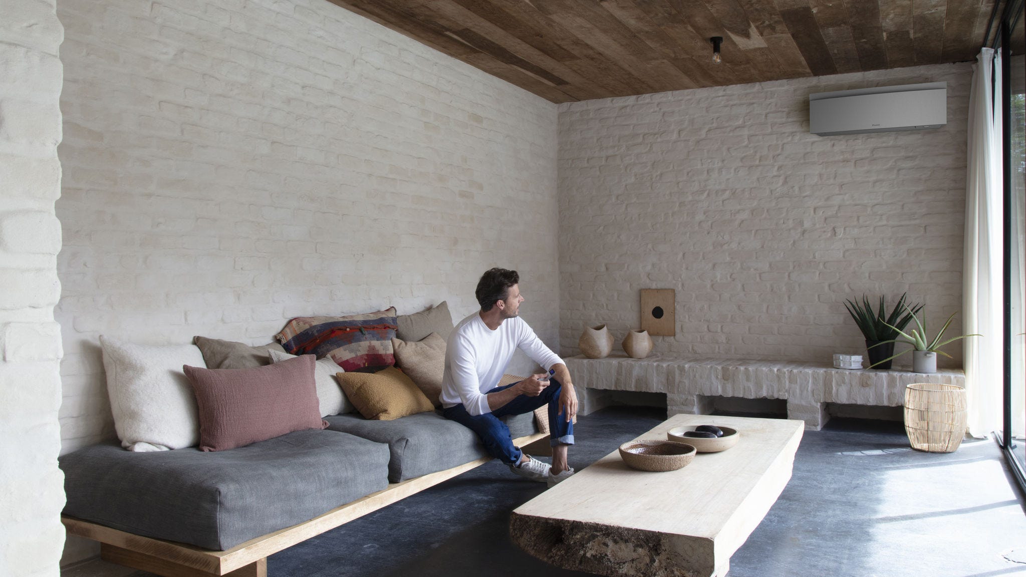 Instalator montujący jednostkę wewnętrzną Stylish na ścianie.