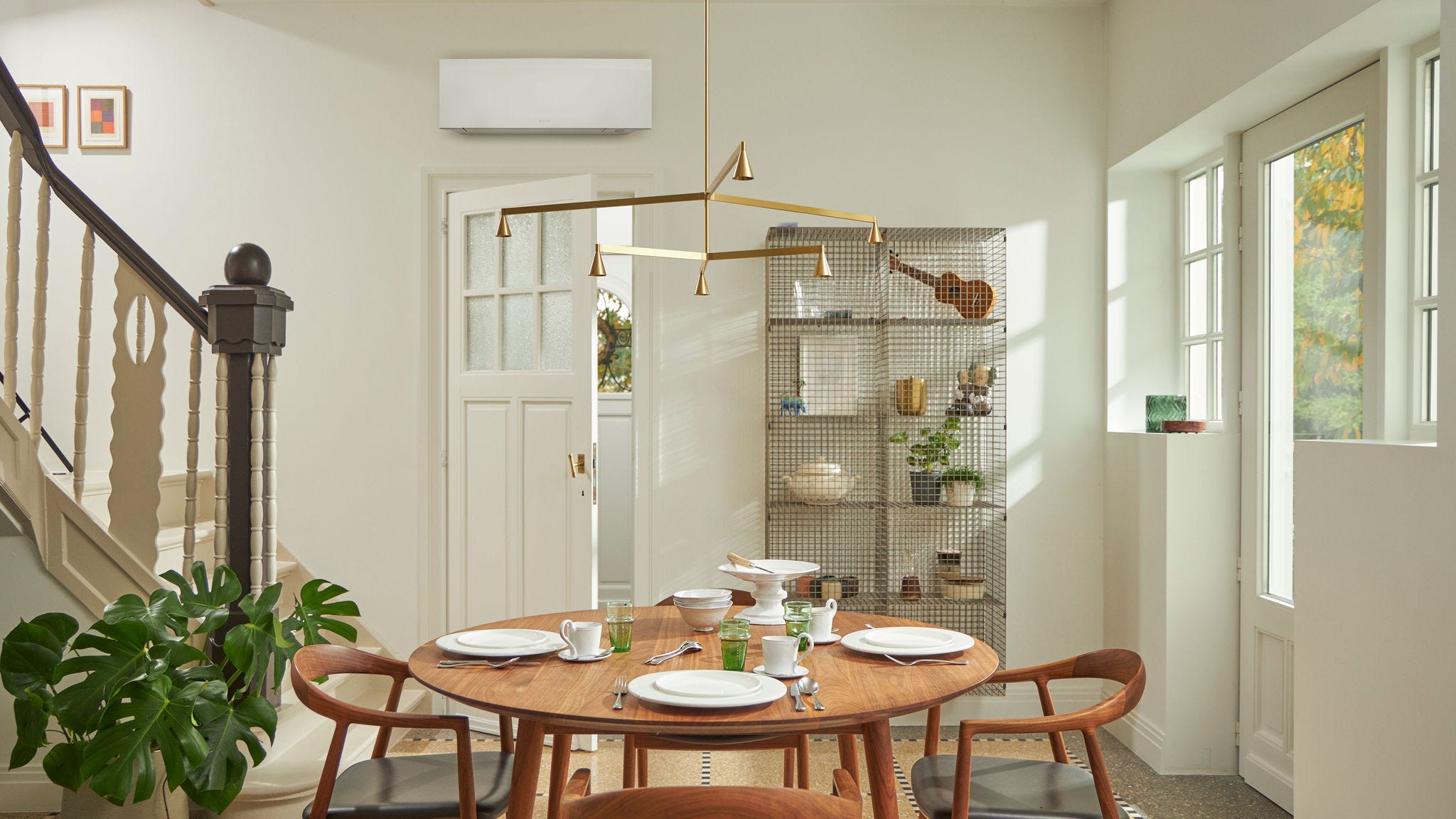 Pokój z dużym oknem, drewnianym stołem i czarną jednostką naścienną.